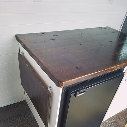 Close-up of a camper van galley with butcher block countertop